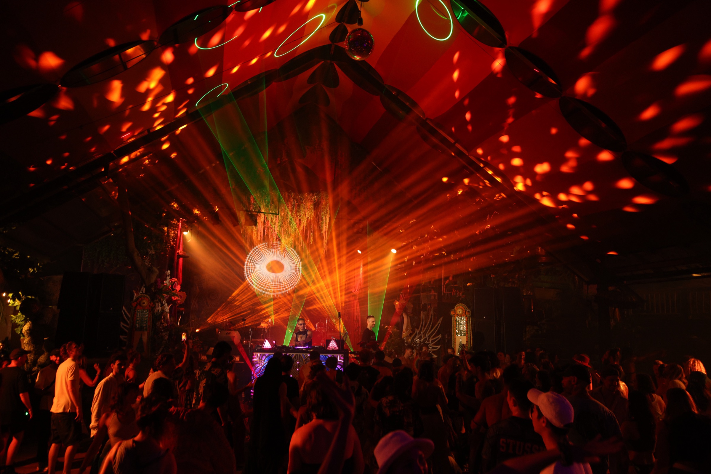 Full crowd and stage with orange, red, and green laser spectacle at JAGWOLF's Bali Spirit Festival 2026 set