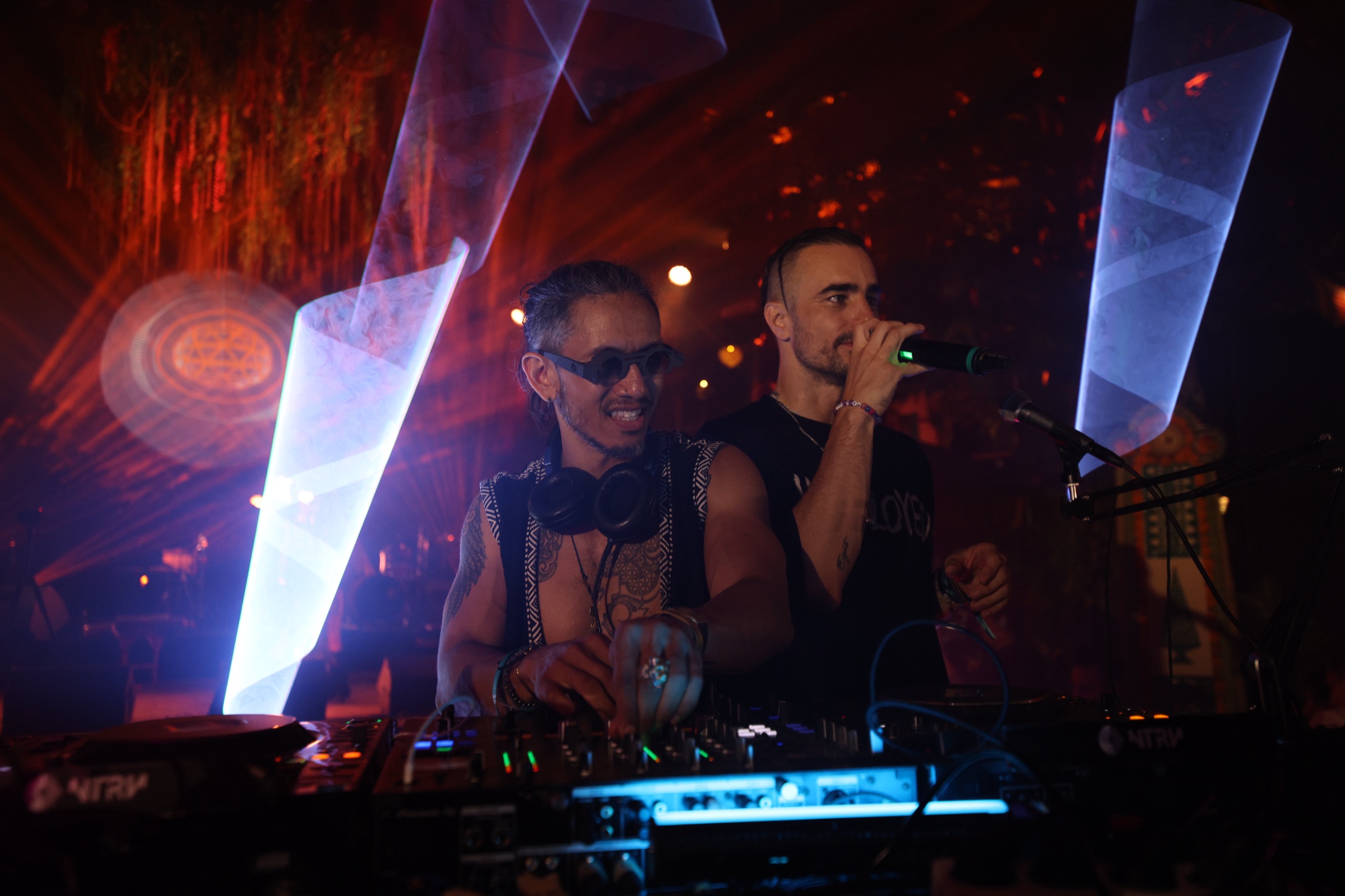 JAGWOLF late set with white laser pillars on deep red background, Miguel singing on handheld mic at Bali Spirit Festival 2026