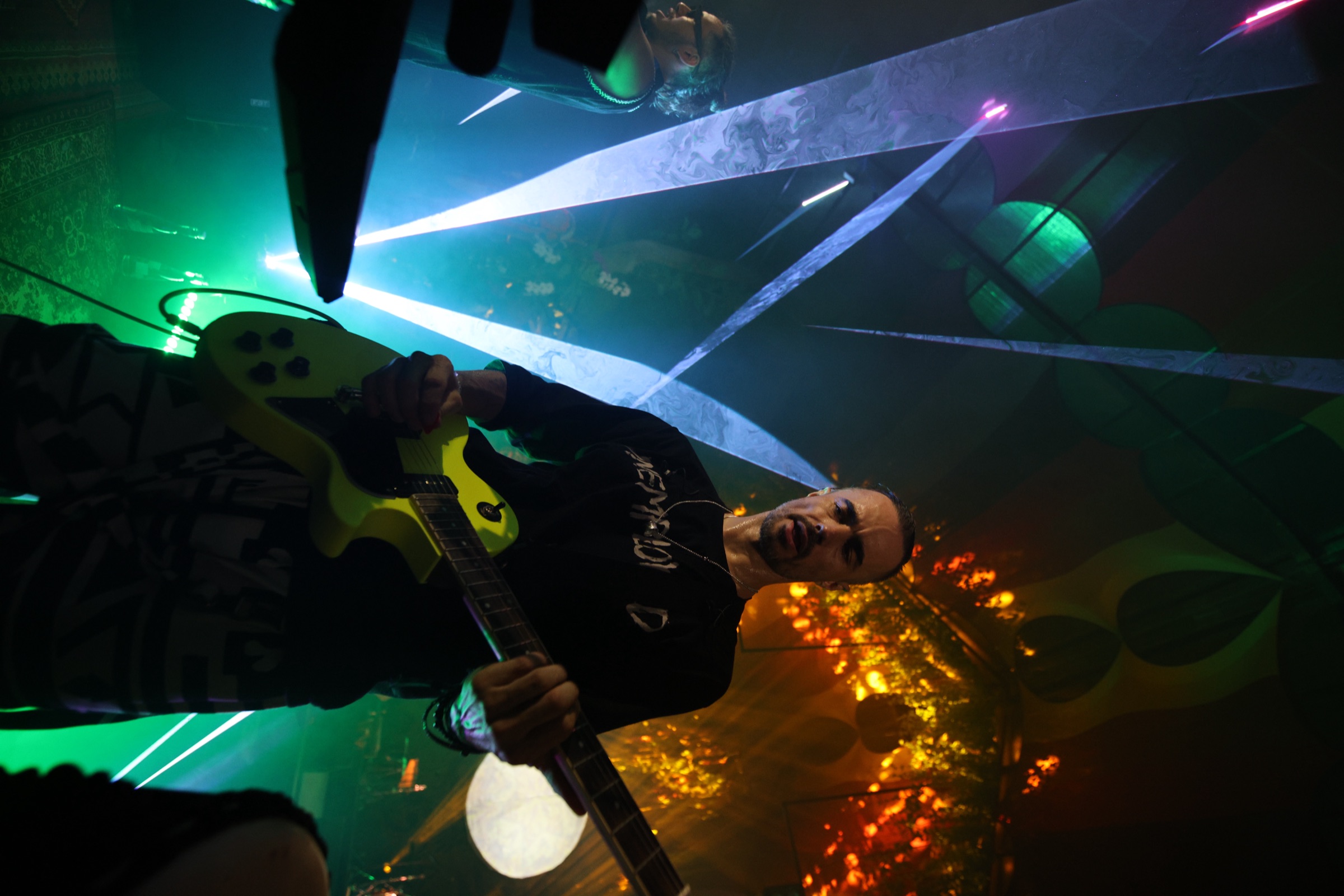 Nova Wolf close-up singing with yellow guitar and white laser V at Bali Spirit Festival 2026